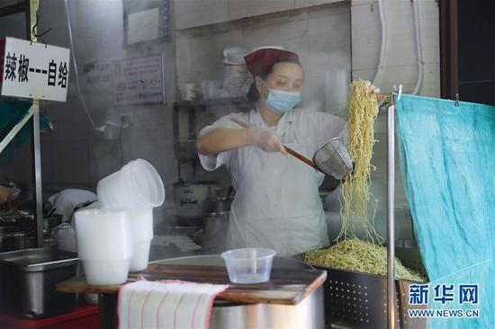 4月22日，武漢市糧道街的家陽“趙師傅”天天紅油熱干面店廚師在制作熱干面。新華社記者 沈伯韓 攝
