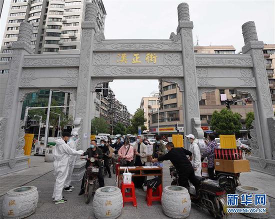  4月16日，進(jìn)出武漢漢正街步行街的人員在掃描健康碼。新華社記者 王毓國 攝